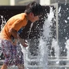 Trẻ em chơi dưới vòi nước để tránh nóng bức tại công viên thành phố Los Angeles, bang California ngày 14/5. (Ảnh: AFP/TTXVN)