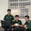 Thiếu tá Thiều Hữu Cường (ngồi giữa) với thiết bị IoT cảnh báo nguy cơ đột quỵ. (Ảnh: TTXVN phát)