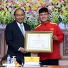 Thủ tướng Nguyễn Xuân Phúc trao tặng Huân chương lao động Hạng Nhì cho cầu thủ Nguyễn Quang Hải. (Ảnh: Thống Nhất/TTXVN)