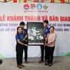 Đại diện Cơ quan thường trú TTXVN tại Thành phố Hồ Chí Minh tặng bức ảnh Chủ tịch Hồ Chí Minh cho Ủy ban Nhân dân xã Nhuận Đức, huyện Củ Chi. (Ảnh: Thu Hương/TTXVN)