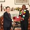 Đại sứ Hoàng Văn Lợi tặng quà lưu niệm Tổng thống Zimbabwe Emmerson Mnangagwa. (Ảnh Đại sứ quán Việt Nam tại Nam Phi/TTXVN phát)