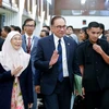Thủ tướng Malaysia (giữa) rời phiên họp Hạ viện sau cuộc đánh giá tín nhiệm, ở Kuala Lumpur. (Ảnh: AFP/TTXVN)