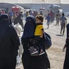 Phụ nữ và trẻ em chuẩn bị rời khỏi trại al-Hol, nơi tạm giữ thân nhân của các đối tượng bị tình nghi là thành viên IS, ở Hasakeh (Syria), ngày 14/8/2022. (Ảnh: AFP/TTXVN)