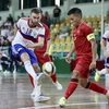 Pha tranh bóng giữa các tuyển thủ Việt Nam (áo đỏ) với cầu thủ Nga. (Ảnh: Thanh Vũ/TTXVN)