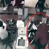 Tên cướp đang khống chế nhân viên ngân hàng. Ảnh cắt từ video. (Nguồn: Báo Đời sống và Pháp luật)