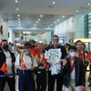 Cổ động viên Việt Nam tại Philippines tặng hoa chào mừng HLV Philippe Troussier và Đội tuyển tại Sân bay Ninoy Aquino. (Ảnh: Minh Tiến/Vietnam+)