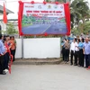 Ban tổ chức tiến hành nghi thức công bố biển công trình "Đường cờ Tổ quốc" tại xã Nhơn Ái, Phong Điền. (Ảnh: Trung Kiên/TTXVN)