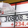 Màn hình điện tử hiển thị chỉ số chứng khoán Nikkei (dưới) tại Tokyo, Nhật Bản. Ảnh: Kyodo/TTXVN)