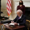 Tổng thống Mỹ Joe Biden ký một sắc lệnh tại Nhà Trắng ở Washington, DC, ngày 21/1/2021. (Ảnh: AFP/TTXVN)