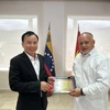 Phó Trưởng Ban Dân vận Trung ương Nguyễn Lam tặng quà lưu niệm Phó Chủ tịch thứ nhất Đảng PSUV Diosdado Cabello Rondón. (Nguồn: Đại sứ quán Việt Nam tại Venezuela)