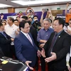 Thủ tướng Phạm Minh Chính thăm gian hàng trưng bày sản phẩm đổi mới sáng tạo. (Ảnh: Dương Giang/TTXVN) 