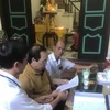 Ủy ban Nhân dân phường Nhật Tân (Tây Hồ), trao Giấy khai tử tại nhà cho đại diện gia đình có người mất. (Ảnh Mạnh Khánh/TTXVN) 