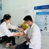 Nhân viên y tế Trung tâm Kiểm soát bệnh tật tỉnh Kiên Giang lấy mẫu xét nghiệm theo dõi điều trị HIV cho một bệnh nhân. (Ảnh: T.G/Vietnam+)