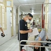Bác sỹ theo dõi tình hình sức khỏe cho một bệnh nhân mắc sốt xuất huyết tại Hà Nội. (Ảnh: Minh Quyết/TTXVN)
