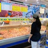 Người tiêu dùng mua thịt lợn tại siêu thị. (Ảnh: TTXVN phát)