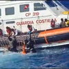 Tàu của Lực lượng Bảo vệ Bờ biển Italy giải cứu người di cư và tìm kiếm thi thể các nạn nhân ở ngoài khơi đảo Lampedusa, ngày 5/8. (Ảnh: AFP/TTXVN)