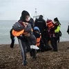 Người di cư được đưa về bãi biển ở Dungeness, phía Đông Nam vùng England, sau khi được giải cứu ở eo biển Channel. (Ảnh: AFP/TTXVN)