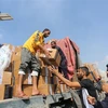 Bốc dỡ hàng viện trợ cho người dân Gaza tại khu vực cửa khẩu Rafah. (Ảnh: THX/TTXVN)