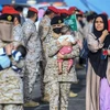 Binh sỹ Saudi Arabia bế em bé Sudan sơ tán tránh xung đột, tại căn cứ hải quân ở Jeddah, ngày 26/4/2023. (Ảnh: AFP/TTXVN)