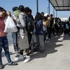 Người di cư từ Mexico chờ lên xe buýt để được trung chuyển khỏi bang Texas, Mỹ ngày 26/9/2023. (Ảnh: AFP/TTXVN)