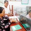 Vợ chồng ông Hoàng Hữu Hiện rất vui khi đến Ngân hàng CSXH huyện Lệ Thủy nhận 100 triệu đồng vốn vay để đầu tư nuôi lợn rừng, lợn nái. (Ảnh: Vietnam+)