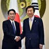 Ngoại trưởng Hàn Quốc Yun Byung Se (phải) và người đồng cấp Nhật Bản Fumio Kishida trong một cuộc gặp ngày 21/3. (Ảnh: AFP/TTXVN)