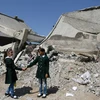 Hai bé gái đứng trước ngôi trường bị phá hủy hoàn toàn do chiến tranh ở dải Gaza. (Ảnh: UNICEF)