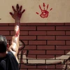 Một người đàn ông đánh dấu lên tường để ghi nhớ ngày hiến sinh. (Ảnh: Reuters)