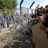 Dòng người di cư tìm cách vượt qua hàng rào dây thép gai để vào các quốc gia châu Âu. (Nguồn: Getty Images)