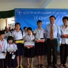 Ông Sum Chi, Chủ tịch Tổng hội người Campuchia gốc Việt Nam, trao tặng phần thưởng cho các học sinh đạt thành tích xuất sắc trong năm học 2014-2015. (Ảnh: Xuân Khu/TTXVN) 