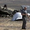 Một nhà điều tra bên cạnh xác chiếc máy bay Airbus A-321 của hãng hàng không Nga Kogalymavia. (Ảnh: AP)