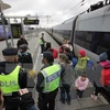Cảnh sát Thụy Điển kiểm tra nhóm người nhập cư tại sân ga ở Malmo. (Nguồn: AFP/TTXVN)