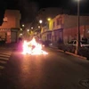 Người biểu tình đốt phá hàng hóa. (Ảnh: EFE)
