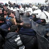 Cảnh sát Hy Lạp ngăn những người biểu tình tại biên giới với Macedonia, gần làng Idomeni ngày 27/3. (Ảnh: AFP/TTXVN)