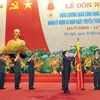 Chủ tịch nước Trương Tấn Sang gắn Huân chương Quân công hạng Nhất lên lá cờ truyền thống của Tổng cục Hậu cần. (Ảnh: Trọng Đức/TTXVN) 