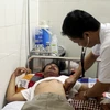 Bác sỹ Bệnh viện Đa khoa thành phố Vinh (Nghệ An) đang thăm khám cho anh Trương Như La. (Ảnh: Tá Chuyên/TTXVN)