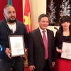 Đại sứ Phạm Quốc Trụ trao giải cho 2 nahf báo Algeria. (Ảnh: Thanh Bình/Vietnam+)