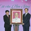 Chủ tịch nước Trần Đại Quang tặng bức tranh chân dung Chủ tịch Hồ Chí Minh cho Đài Tiếng nói Việt Nam. (Ảnh: Nhan Sáng/TTXVN)