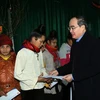 Chủ tịch Ủy ban Trung ương MTTQ Việt Nam Nguyễn Thiện Nhân tặng quà Tết cho gia đình nghèo ở bản tái định cư. (Ảnh: Nguyễn Dân -TTXVN)