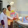Phó Bí thư Thành ủy Thành phố Hồ Chí Minh Võ Thị Dung tặng quà cho gia đình những công dân tuổi Đinh Dậu ra đời đầu tiên. (Ảnh: Xuân Dự/TTXVN)