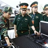 Trung tướng Phan Văn Giang với các đại biểu thăm khu trưng bày vũ khí, thiết bị phục vụ chống khủng bố. (Ảnh: An Đăng/TTXVN)