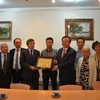 Phó Chủ tịch Quốc hội Phùng Quốc Hiển trao tặng quà cho Hội người Việt Nam tại Pháp. (Ảnh: Bích Hà/TTXVN)