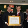 Trưởng Cơ quan thường trú TTXVN tại Phnom Penh, nhà báo Trần Chí Hùng nhận huân chương Hạng Nhất (hạng Thephaden). (Ảnh: TTXVN)