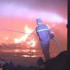 Lực lượng chữa cháy đang nỗ lực dập lửa. (Ảnh: Nguyễn Văn Việt/TTXVN)