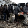 Người nhập cư xếp hàng nhận lương thực cứu trợ tại một khu trại tạm ở thủ đô Paris, Pháp ngày 2/1. (Nguồn: EPA-EFE/TTXVN)