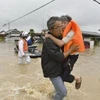Hỗ trợ người dân sơ tán do nước lũ dâng cao tại Kurashiki, tỉnh Okayama ngày 7/7. (Nguồn: Kyodo/TTXVN)