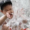 Một bé trai Hàn Quốc nghịch nước để tránh nóng. (Nguồn: BBC)