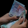 Kiểm tiền bolivar của Venezuela tại Caracas ngày 20/8. (Ảnh: THX/TTXVN)