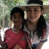 Cậu bé Campuchia chụp ảnh cùng nữ du khách. (Nguồn: nextshark.com)