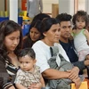 Người nhập cư chờ được hỗ trợ tại một trung tâm nhân đạo ở thị trấn McAllen, bang Texas, Mỹ. (Ảnh: AFP/TTXVN)